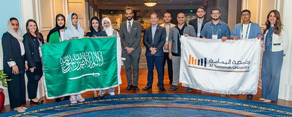 The flag of Saudi Arabia next to a banner for Al Yamamah University.