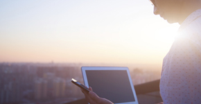 man-with-tablet-overlooking-city-sunrise-background.jpg